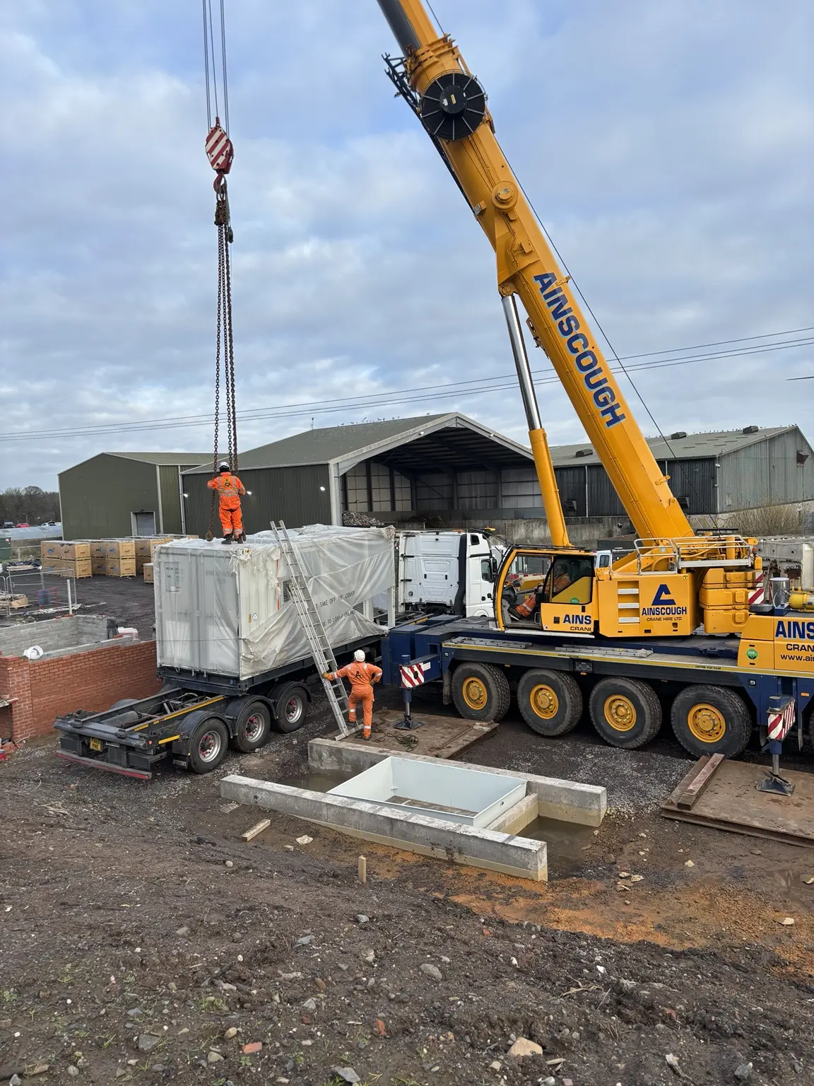 Mobile crane lifting modular electrical equipment during renewable-energy construction